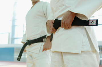 karate students lined up with one straightening their black belt